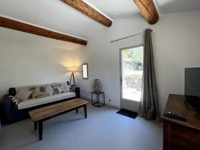 a room with a bed and a table and a window at Bastidon avec vue et piscine au coeur du Luberon in Céreste
