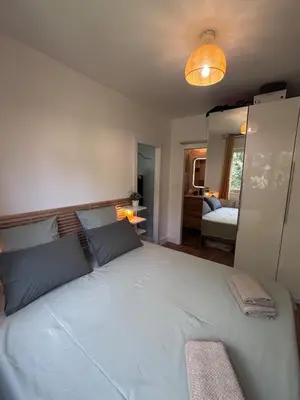 a bedroom with a large white bed with blue pillows at T2 Aurélia in Aix-en-Provence