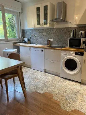 a kitchen with a washing machine and a table at T2 Aurélia in Aix-en-Provence