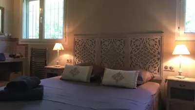 a bedroom with a large bed with two lamps at Les Carrairades in Mollégès