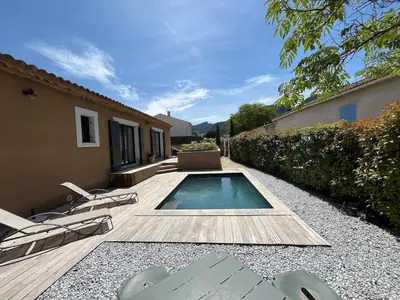 a backyard with a swimming pool and chairs and a house at House with a view of Luberon and a pool in Maubec