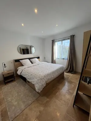 a bedroom with a large bed and a window at House with a view of Luberon and a pool in Maubec