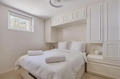 a white bedroom with a large white bed with a window at Appartment 5 min walking from city center in Aix-en-Provence