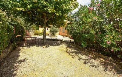 a gravel driveway with a tree in a yard at Maison Avec Piscine Privée in Lacoste