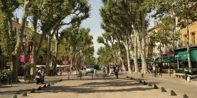 a street in a city with trees and people at Studio charmant centre historique au calme in Aix-en-Provence