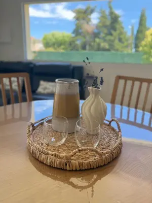 a tray with a vase and two glasses on a table at Le Quatre Relax in Aix-en-Provence