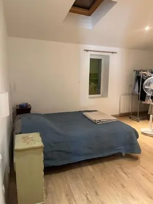 a bedroom with a bed with a blue blanket at Suite dans maison de village au coeur de Pertuis in Pertuis