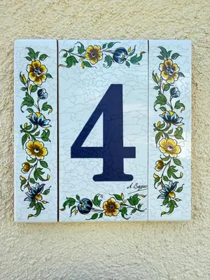 a plaque with a number four with flowers on it at Cozy studio with air conditioning & pool & parking in Aix-en-Provence