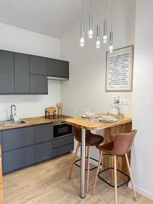 a kitchen with a wooden table and chairs in a kitchen at Cozy studio with air conditioning & pool & parking in Aix-en-Provence