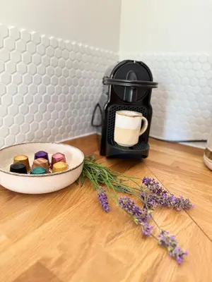 a table with a coffee maker and a plate of pastries and flowers at Cozy studio with air conditioning & pool & parking in Aix-en-Provence