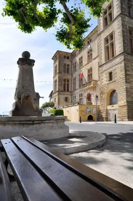 a park bench in front of a building at Studio cosy proche d Aix en Provence climatisé in Éguilles