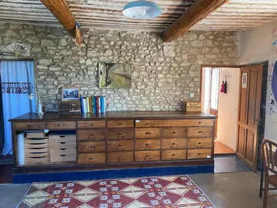 a large wooden dresser in a room with a stone wall at Il était une fois à Lagnes in Lagnes