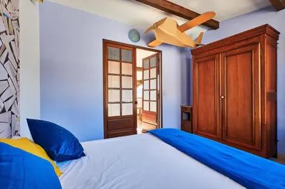 a bedroom with a bed and a ceiling fan at Le Fort de Bramafan in Caumont-sur-Durance