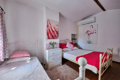 a bedroom with two beds and a pink flamingo picture at Le Fort de Bramafan in Caumont-sur-Durance
