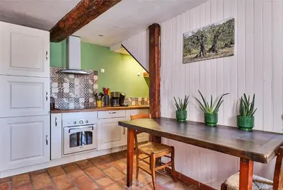 a kitchen with a wooden table in a room at Le Fort de Bramafan in Caumont-sur-Durance