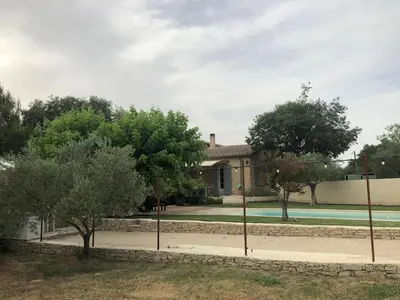 a house with a swimming pool and trees in front at Gîte ,studio dans le village de lagnes in Lagnes