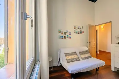 a white room with a chair and a window at Splendide appartement au cœur du centre historique in Aix-en-Provence