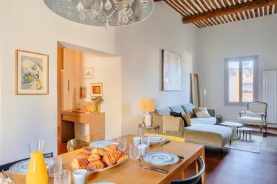 a living room with a table and a couch at Splendide appartement au cœur du centre historique in Aix-en-Provence