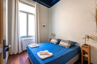 a bedroom with a blue bed with towels on it at Splendide appartement au cœur du centre historique in Aix-en-Provence