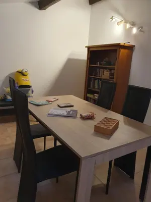 a wooden table with chairs and a book shelf at Évasion provençale in Saint-Cannat