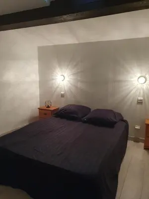 a bedroom with a bed with two lights on the wall at Évasion provençale in Saint-Cannat