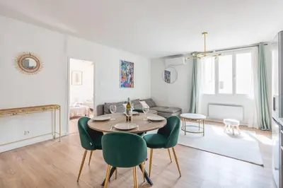 a living room with a table and green chairs at Appartement confortable L'Éclat Doré in Pertuis