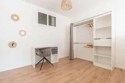 a white room with a fireplace and a closet at Appartement confortable L'Éclat Doré in Pertuis