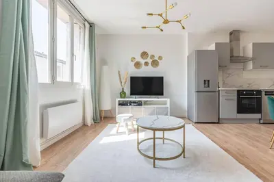 a living room with a table and a kitchen at Appartement confortable L'Éclat Doré in Pertuis