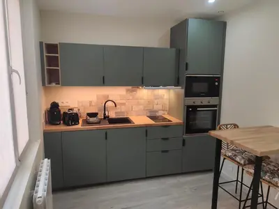 a kitchen with gray cabinets and a counter top at Escapade dans le Luberon in Cavaillon