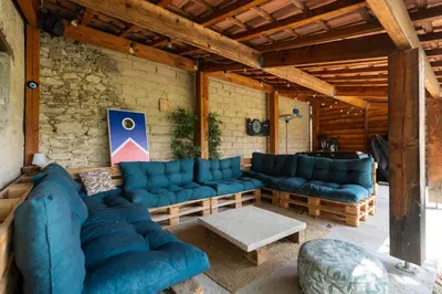 a living room with blue couches and a stone wall at Mas Provençal chic et élégant - Alpilles et Luberon in Sénas