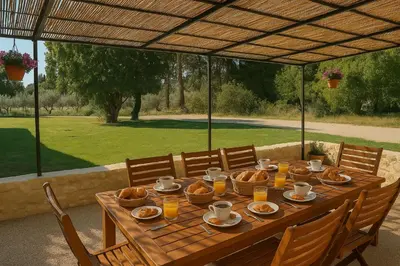 a wooden table with food and baskets of bread on it at Le Jas de la Cascade in Les Vignères