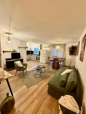 a living room with a green couch and a table at Suite appartement in Châteaurenard