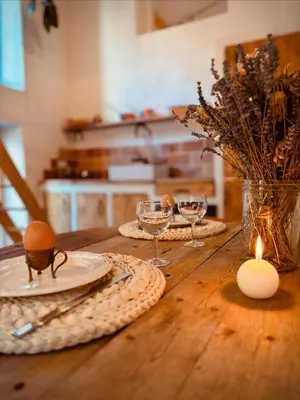 a wooden table with plates and glasses and a candle at Le mazet du cavalier in Puyvert
