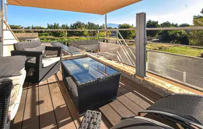 a deck with a glass table and chairs on a balcony at Villa Avec Piscine Privée in Carpentras