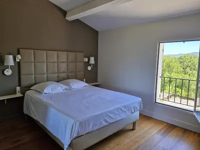a bedroom with a bed and a large window at La Canopée en Provence - Piscine, Vue sur le Mont Ventoux ! in Carpentras