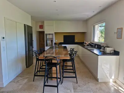 a kitchen with a wooden table and chairs in it at La Canopée en Provence - Piscine, Vue sur le Mont Ventoux ! in Carpentras