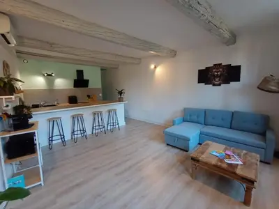 a living room with a blue couch and a table at L'escale Cavaillonnaise in Cavaillon