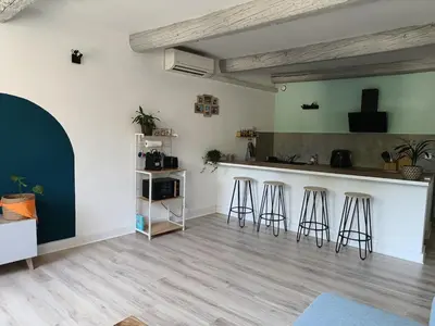 a living room with a counter and bar stools at L'escale Cavaillonnaise in Cavaillon