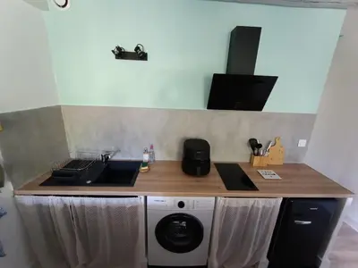 a kitchen with a sink and a washing machine at L'escale Cavaillonnaise in Cavaillon