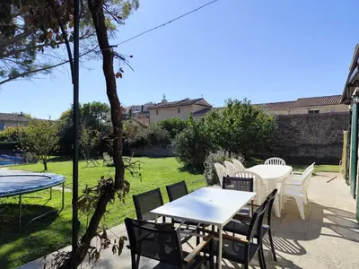 a patio with tables and chairs in a yard at Vaste villa , piscine , garage pour vélos et motos , grand parking in Caromb