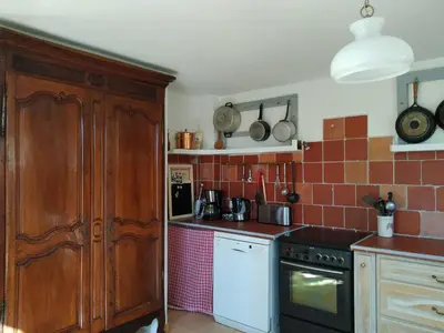 a kitchen with a stove and a counter top at Vaste villa , piscine , garage pour vélos et motos , grand parking in Caromb