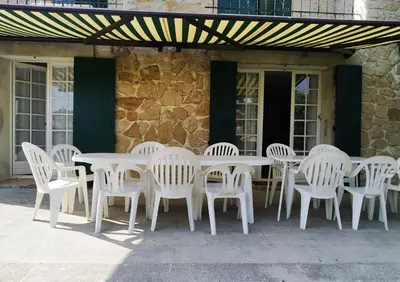 a white table and chairs under awning on a patio at Vaste villa , piscine , garage pour vélos et motos , grand parking in Caromb