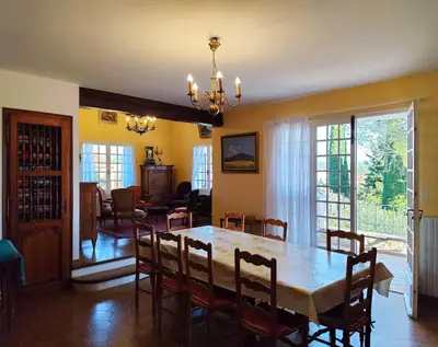 a dining room and living room with a table and chairs at Vaste villa , piscine , garage pour vélos et motos , grand parking in Caromb