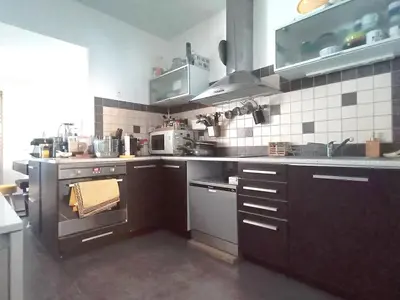 a kitchen with stainless steel appliances and brown cabinets at Quiet ground floor, air conditioning, garden, 3 bedrooms, 7 people max in Salon-de-Provence