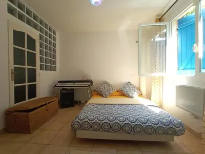 a bedroom with a bed and a piano at Quiet ground floor, air conditioning, garden, 3 bedrooms, 7 people max in Salon-de-Provence