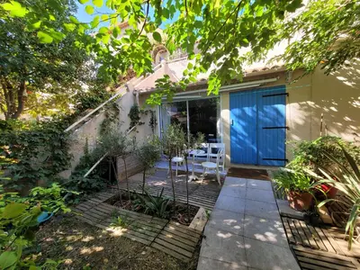 a house with a blue door and a patio at Quiet ground floor, air conditioning, garden, 3 bedrooms, 7 people max in Salon-de-Provence