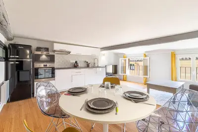 a kitchen and dining room with a white table and chairs at Aixora - Centre historique - Tout à pied & parking in Aix-en-Provence