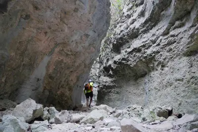 a person walking through a rocky canyon at Les Tournillayres in Bédoin