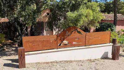 a wooden bench sitting in front of a building at Les Tournillayres in Bédoin