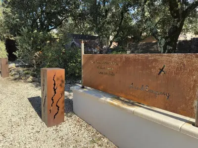 a sign with writing on it next to a wall at Les Tournillayres in Bédoin